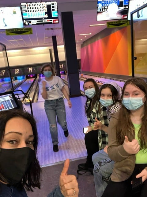A photo of young islanders giving thumbs up at a bowling alley.