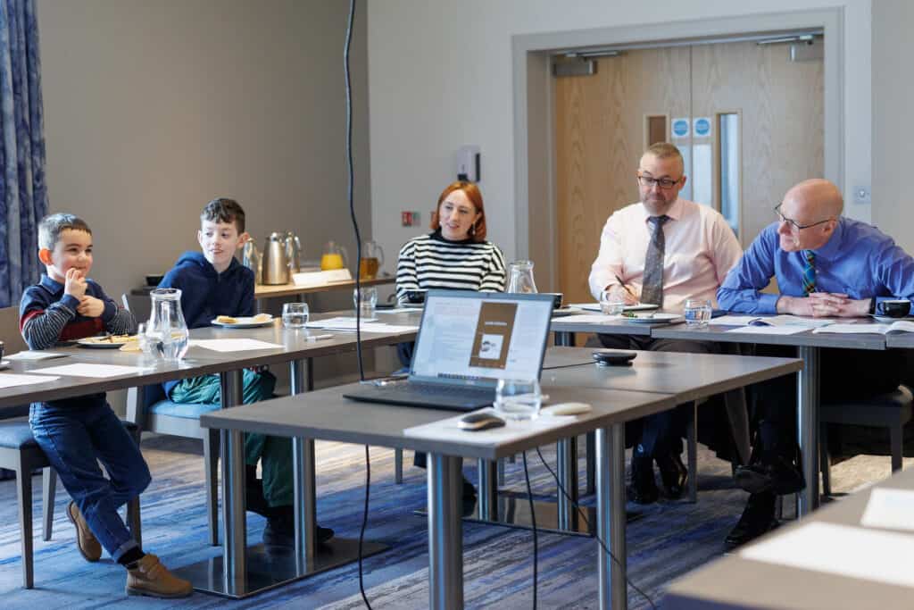 People sitting round board table talking. Hotel, Stornoway. 