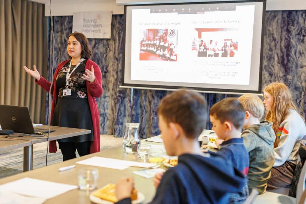 Presenter and powerpoint. Group of young people round table