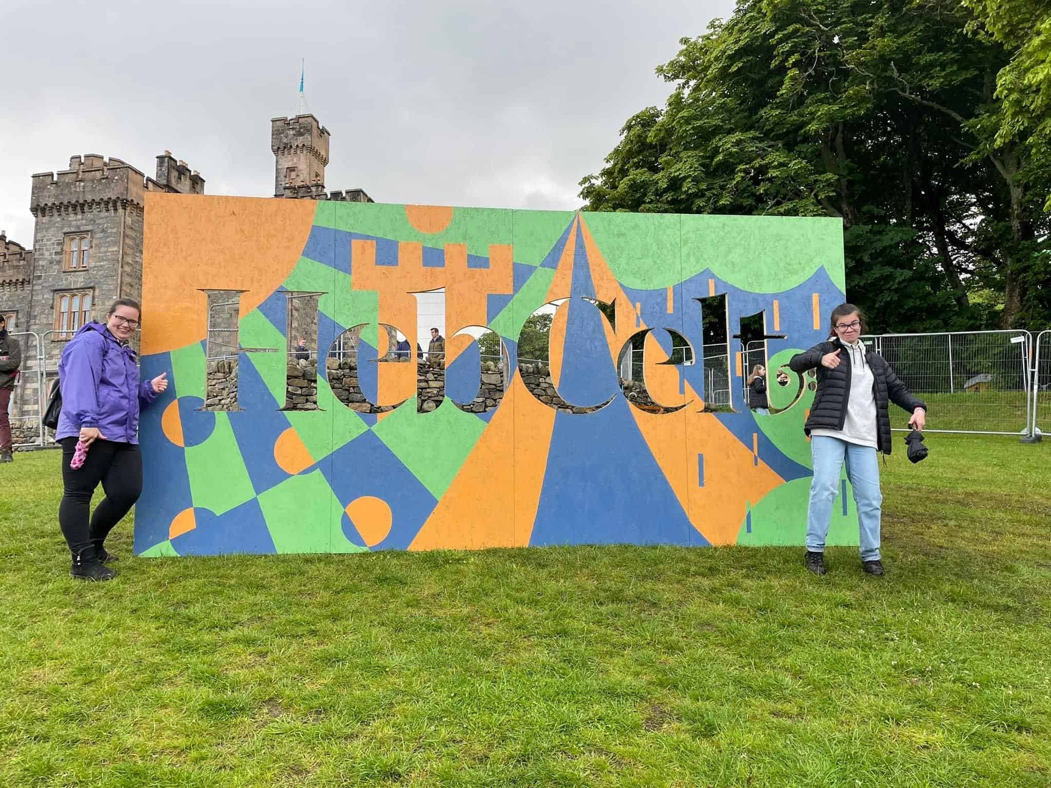 Hebcelt artwork board and two young people posing beside it