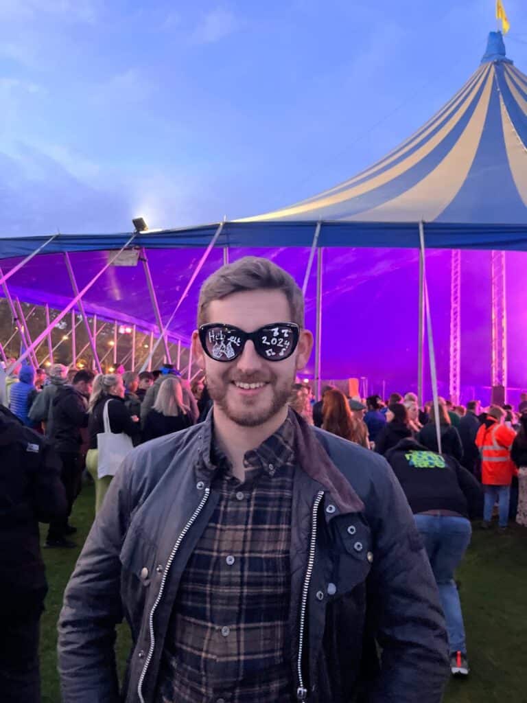 A HebCelt attendee posing with the 'HebCelt 2024' sunglasses on.