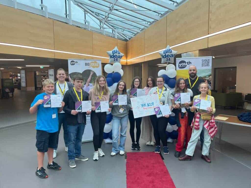 group of smiling young people holding certificates