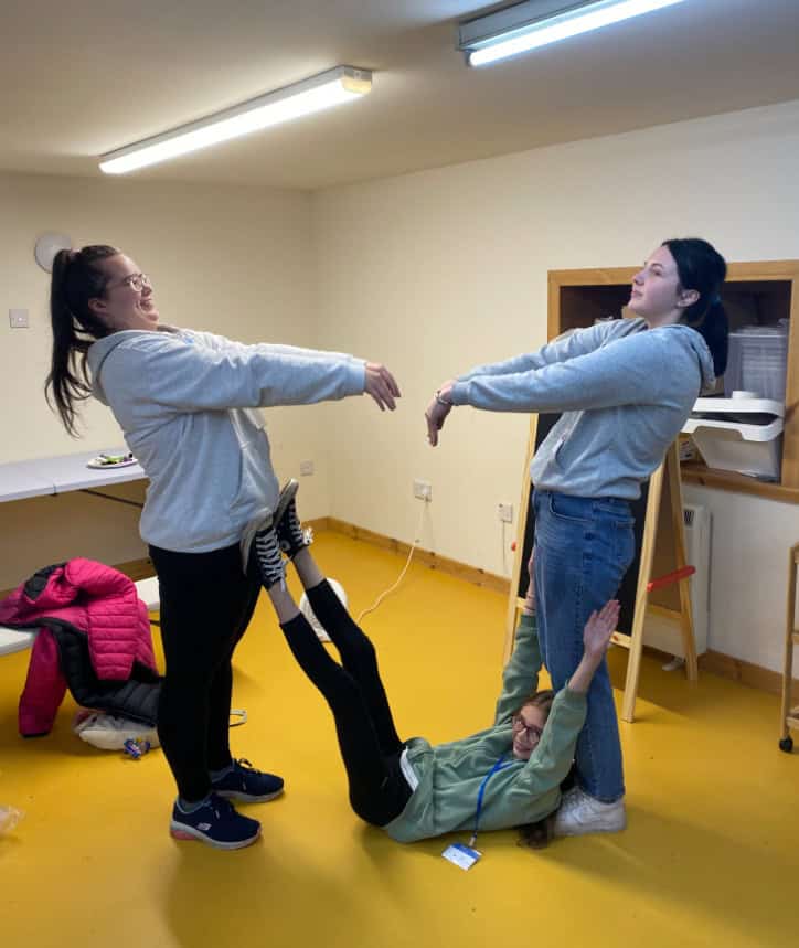 three young people making a triangle shape