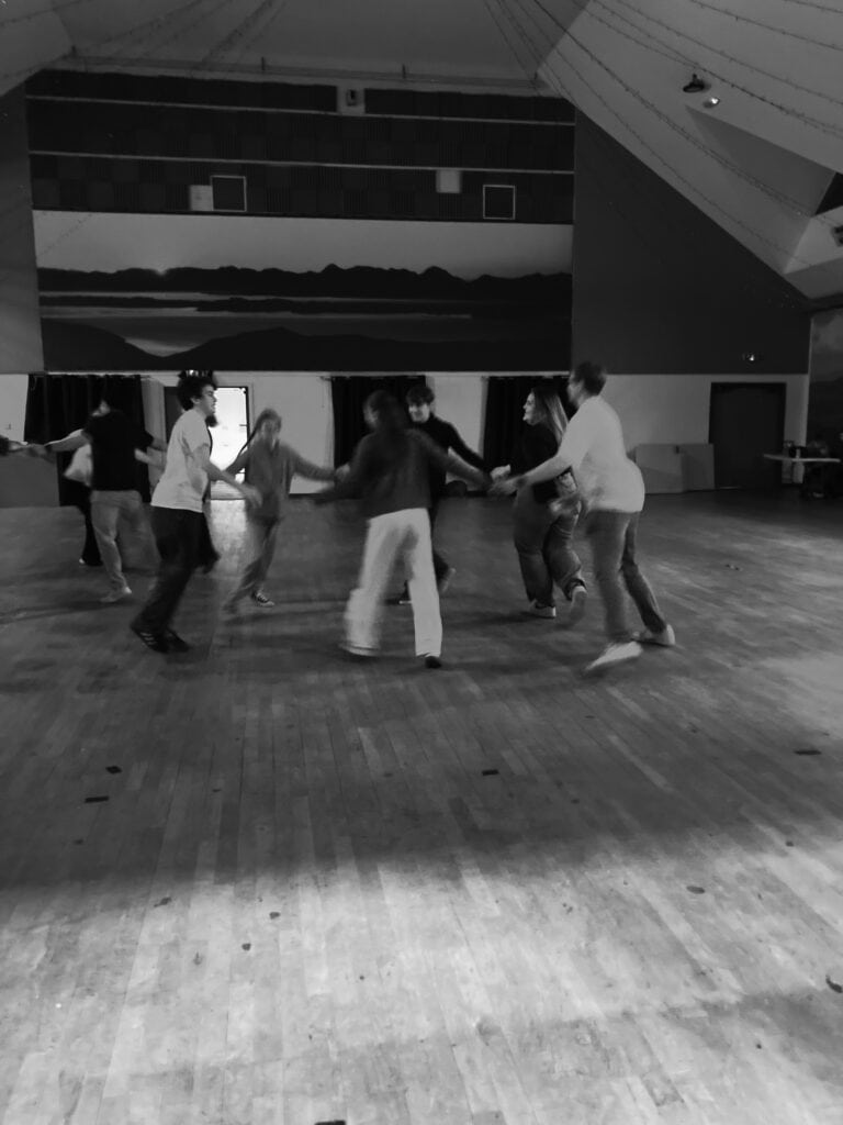 group of people dancing in a circle holding hands